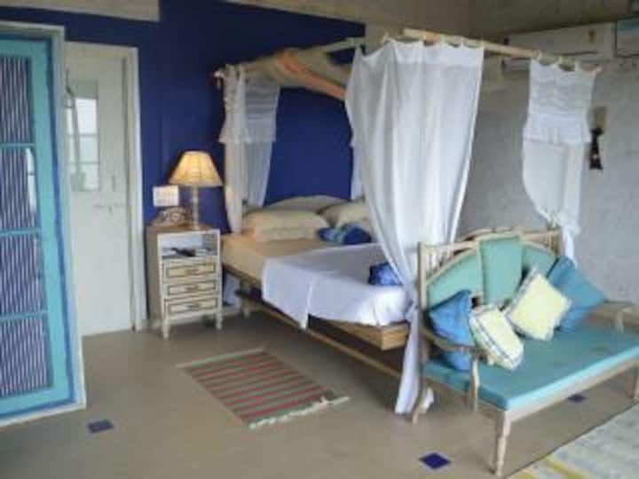 Cobaltblaues Schlafzimmer mit antikem Bett und Sofa