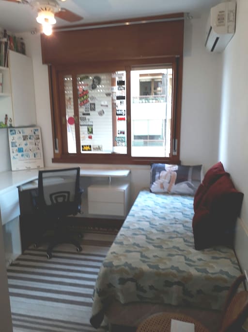 quarto disponível com bancada de trabalho, ar condicionado e cama de solteiro