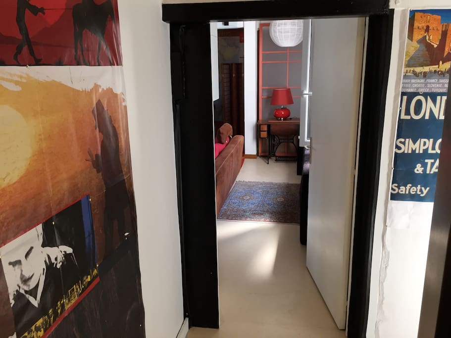 Porte ouverte sur l'appartement, vue depuis le sas d'entrée, angle d'ascenseur à droite