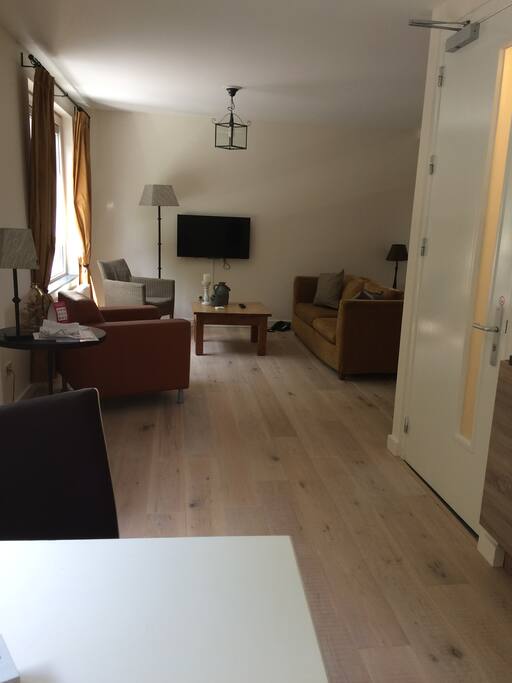 Grote woonkamer met tv en mooi uitzicht