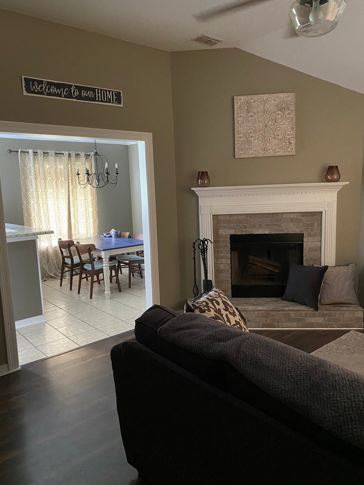 Камин во дневна соба, кауч, поглед на јадење во кујната. 