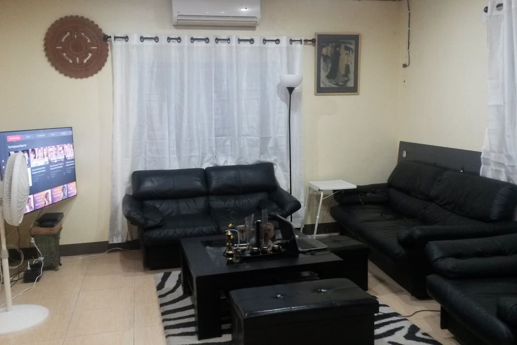Living room with flat screen, AC, fan and large comfy sofa