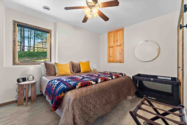 Lower level king bed area includes a pack n play for a little one to use also. This is a quiet sleeping space tucked away and also is nearby the lower level bathroom and includes a closet for your belongings. 