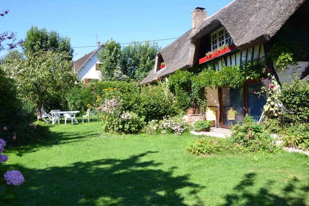 Une pelouse beaucoup plus grande est située sur le côté de la maison, face à la forêt.