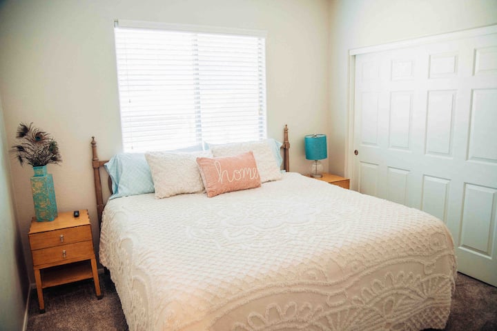 Dormitorio "bohemio" 2 con televisor inteligente de 50 pulgadas, banco, armario, vestidor, ropa de cama y almohadas adicionales, mesitas de noche, lámpara, lavandería adyacente, baño del pasillo al otro lado. 