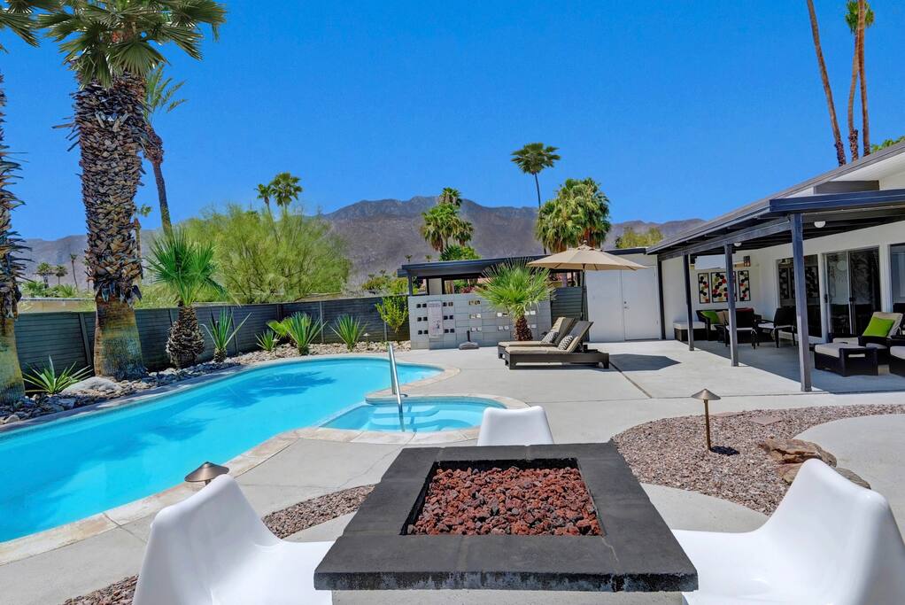 Expansive backyard, surrounded by mature palms and desert landscaping.