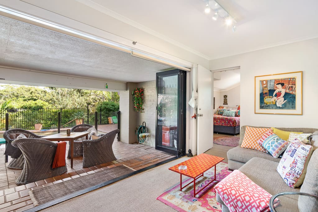 The sitting room opens directly onto the pool terrace. There's a glass pool fence separating it from the pool