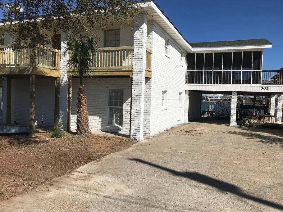 View from double concrete driveway - large screened porch with carport on ground level