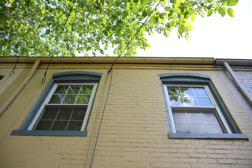 It is surrounded by green foliage, with the bedroom windows looking over the garden and the church behind.