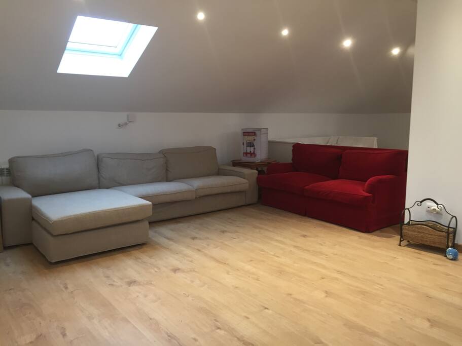 Habitación 80 m2 diáfana, muy luminosa (3 Velux), con un sofá cama (rojo) y cama nido para dos personas.