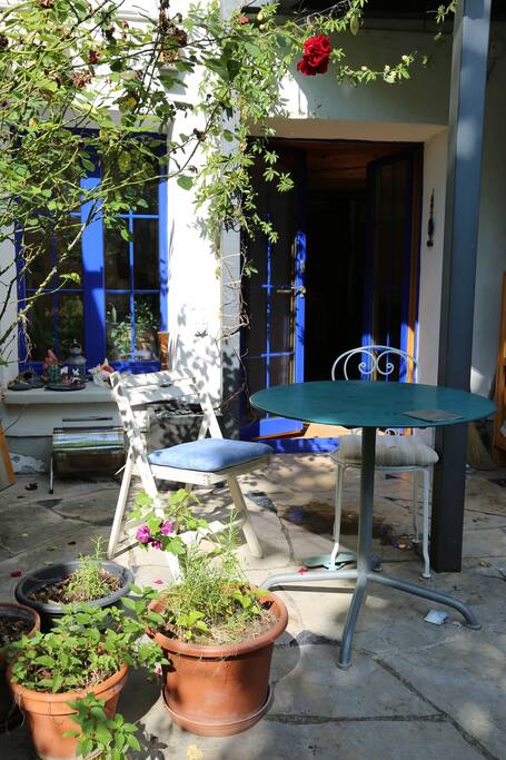 Vue sur l'entrée de la chambre depuis le jardin. Coin déjeuner et repos