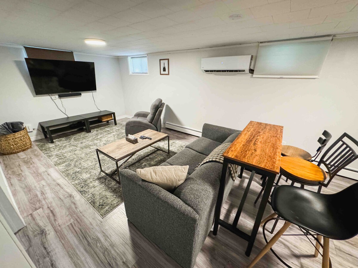 พื้นที่นั่งเล่นชั้นล่างมีทีวีพร้อมเคเบิลและซาวด์บาร์ระดับพรีเมียมโซฟาปรับนอนควีนไซส์แบบดึงออกได้เก้าอี้นอนและโต๊ะสูงพร้อมเก้าอี้สตูล 