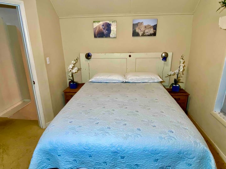 Chambre Queen à l'étage devant la maison au-dessus du porche. 