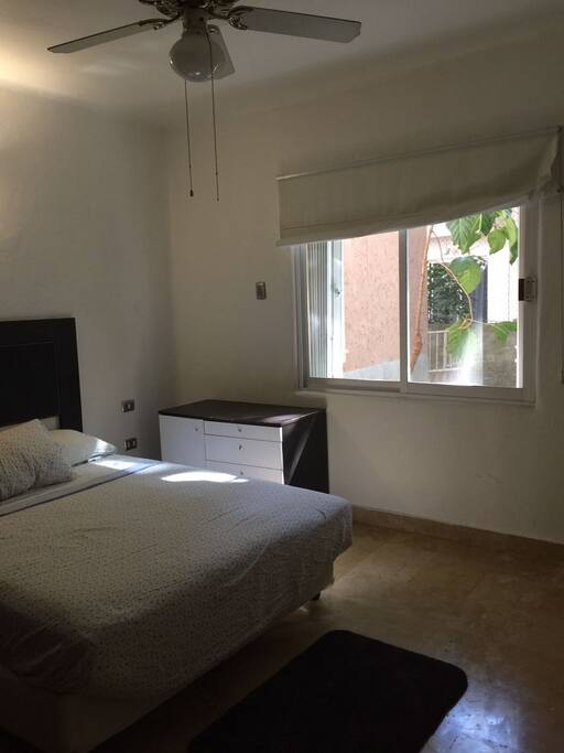 Habitación con una cama matrimonial, aire acondicionado, closet y TV.