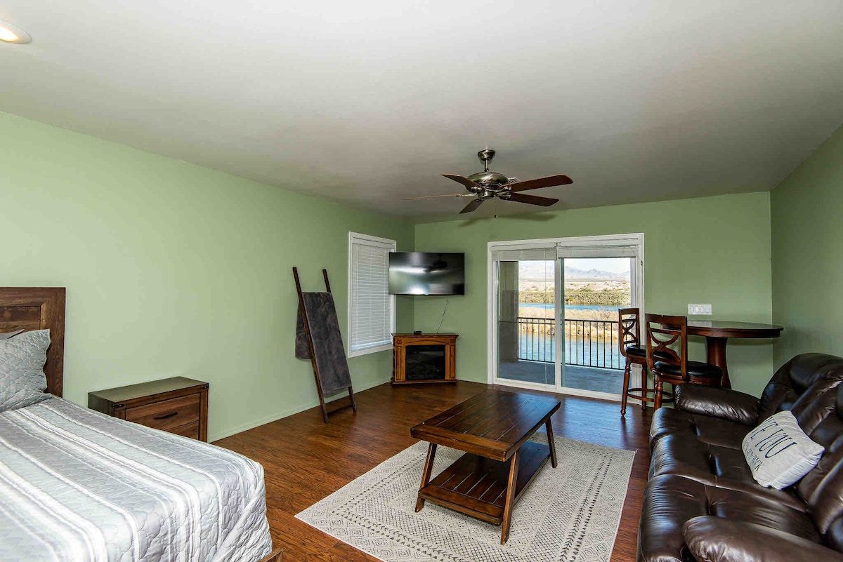 Dormitorio principal en la planta superior con chimenea eléctrica y zona de estar y cama tamaño queen. El control deslizante sale a la terraza del tercer nivel