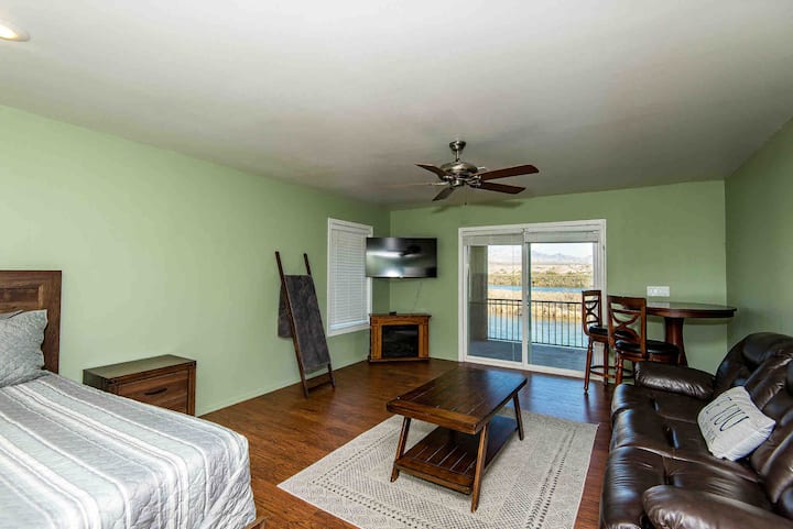 غرفة نوم رئيسية في الطابق العلوي مع مدفأة كهربائية ومنطقة جلوس وسرير بحجم كبير. يذهب المنزلق إلى سطح السفينة في المستوى الثالث