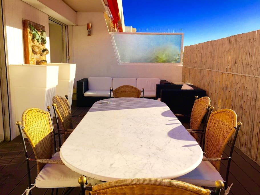 Grande terrasse avec coin salon et transat.