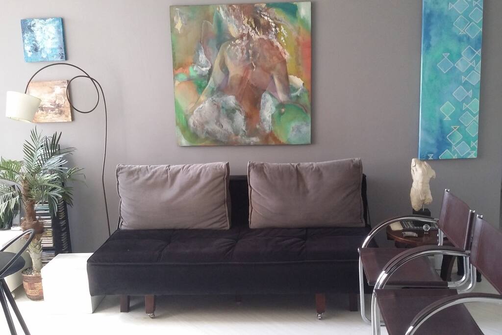 Sofá que se transforma em cama de casal adicional, quadros.