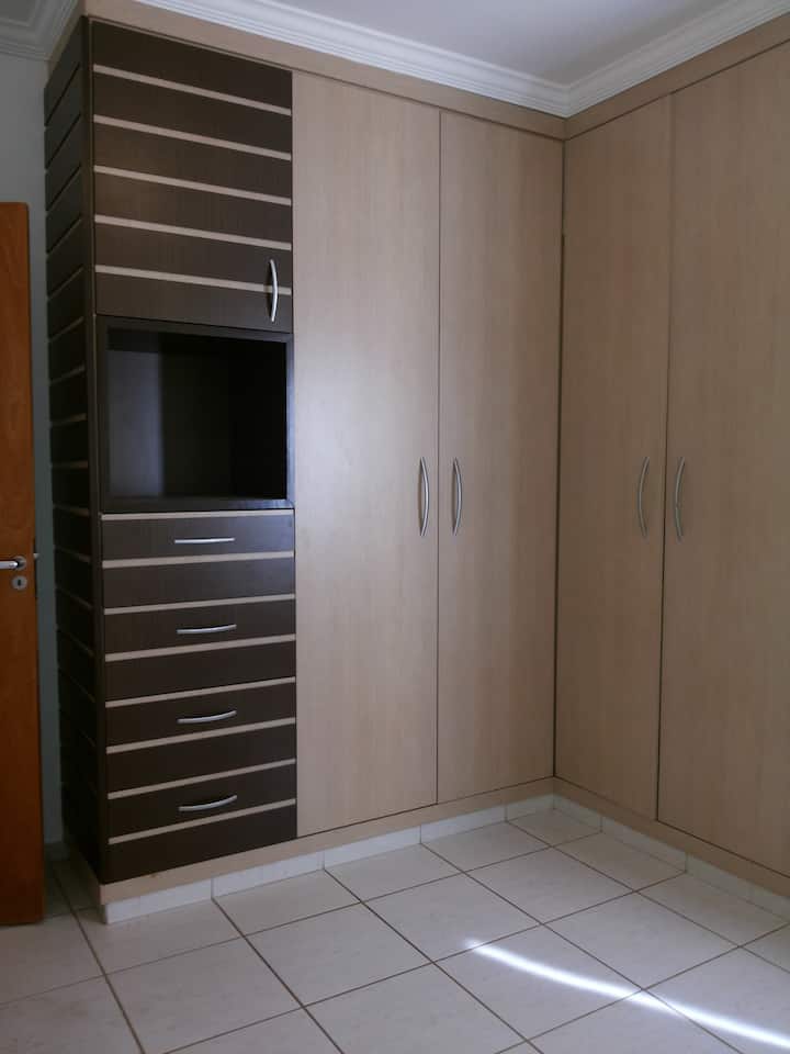 Големи гардероби в спалнята с много чекмеджета и закачалки.