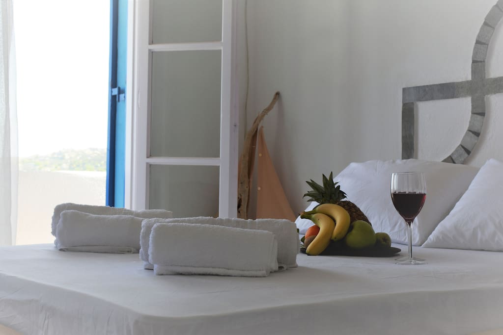 Main bedroom with a king size handmade bed and a sofa-bed , private bathroom and balcony