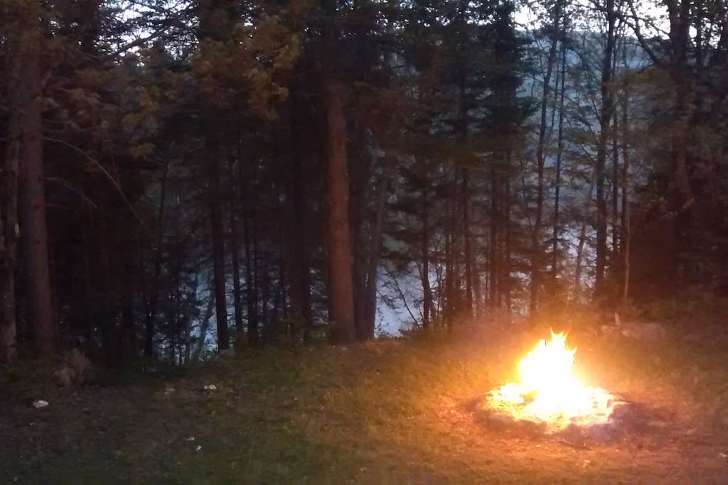 Espace de feu de camp et rivière Ouareau passant sur la propriété.