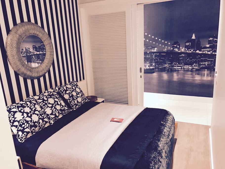 Manhattan themed wall montage across queen sized bed with lamplights
