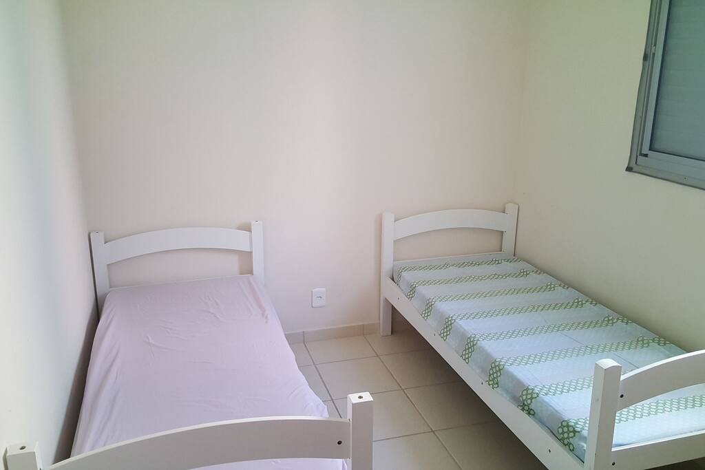 Dormitório com 2 camas de solteiros e ventilador de teto