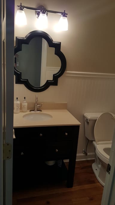 Powder room is located between the kitchen and the living room.