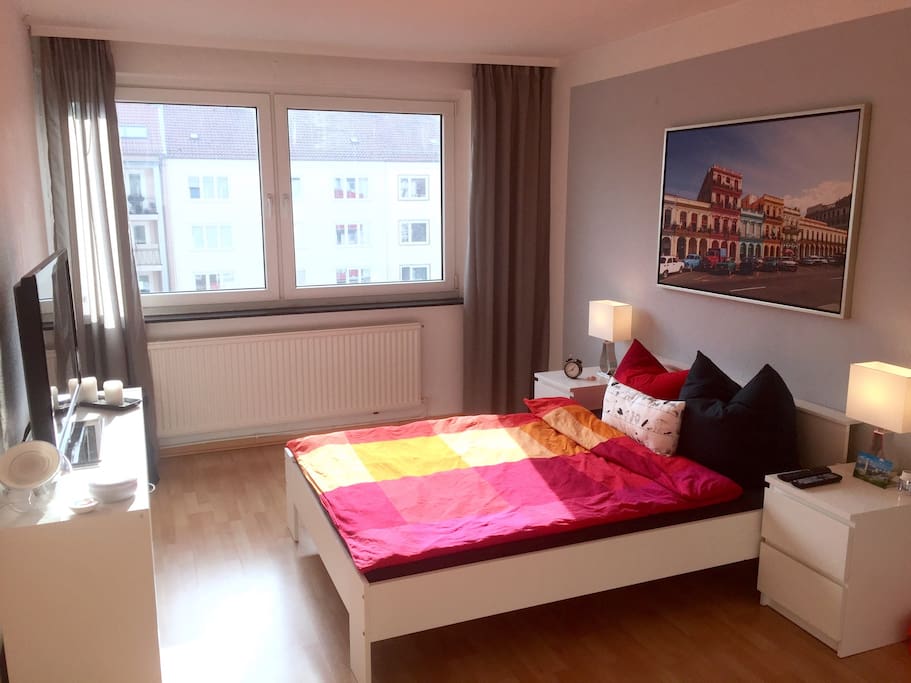 Schlafzimmer mit Fernseher und Kleiderschrank