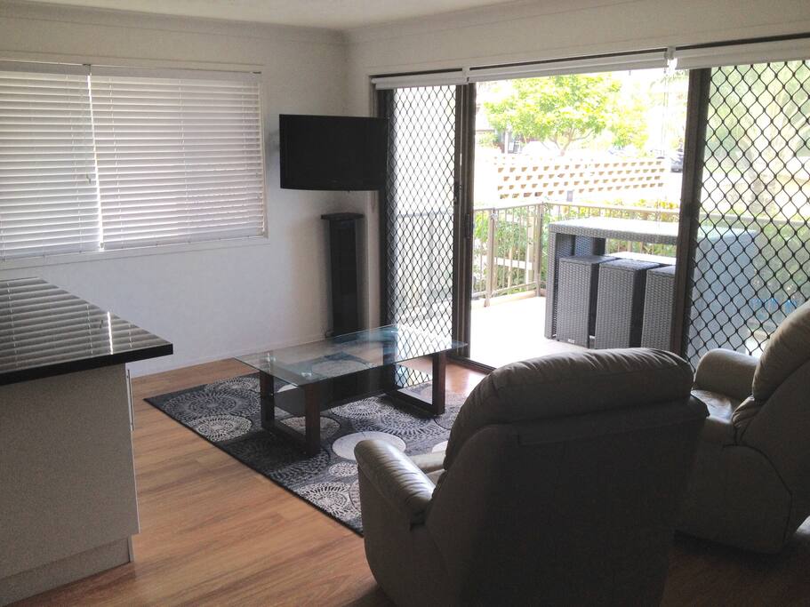 Lounge room with comfy leather recliner chairs, TV and reverse cycle air conditioning