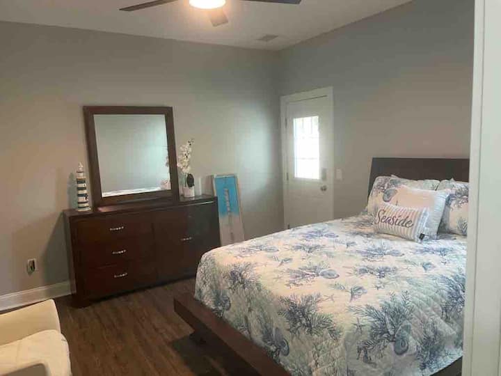 chumba kikuu cha kulala kilicho na mlango wa kujitegemea kupitia nyuma ya nyumba.  