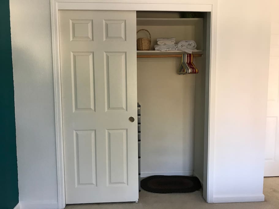 Closet with hangers, storage, and clean towels