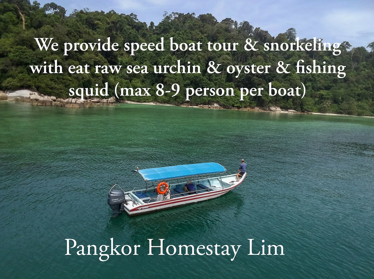 A speed boat is anchored in calm waters surrounded by lush greenery and rocky shoreline. A person can be seen on board, while the clear water reflects the natural scenery. Text overlay indicates available snorkeling tours and fishing options for small groups.