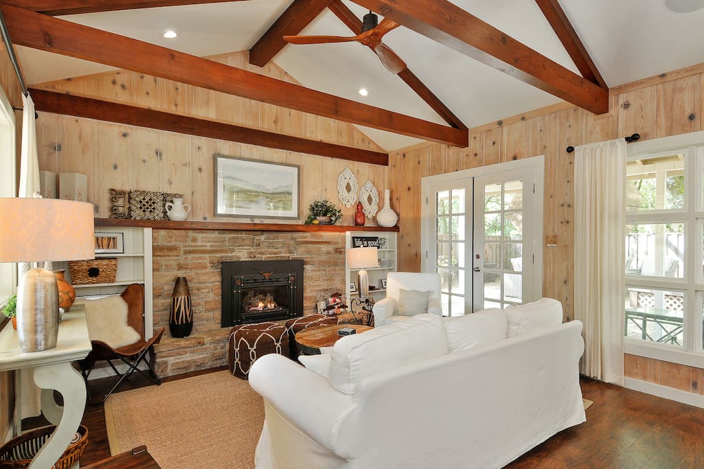 Rustic walls, a natural stone fireplace and wooden beamed ceilings in the living room creates a lodge like feeling of casual elegance.
