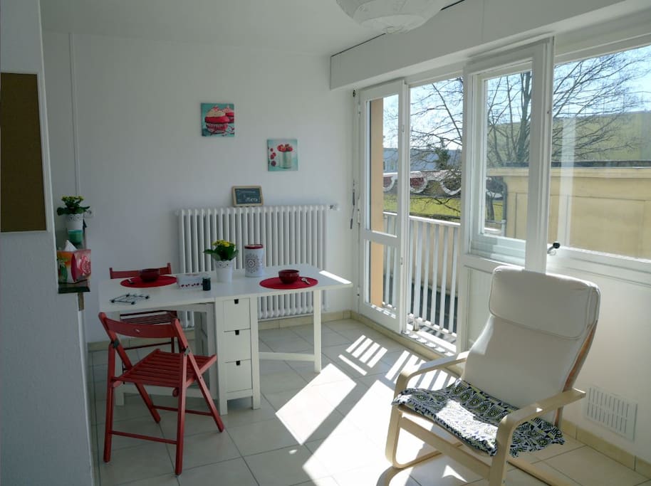 Une grande table au soleil, idéale pour manger et/ou travailler, accès à la cuisine par le bar et un fauteuil au soleil.