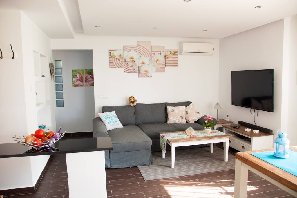 Your living room, where you can enjoy a 55" TV with English, German and Spanish SAT-TV, A/C and a big Sofa, which can be turned into a very comfortable sofa bed.