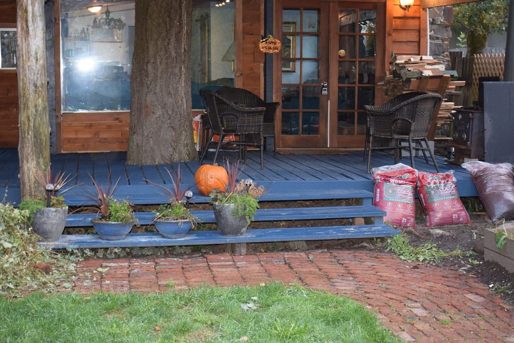 Covered front porch with seating, outdoor fireplace and gas cooking grill.