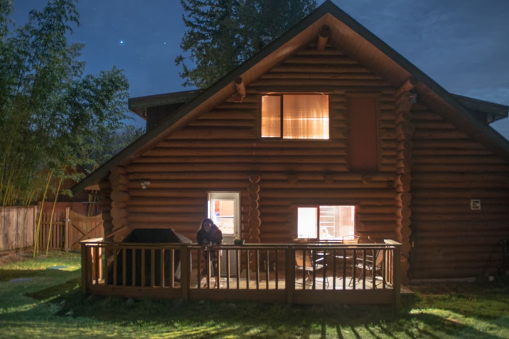 View of the back porch of the log cabin at night.