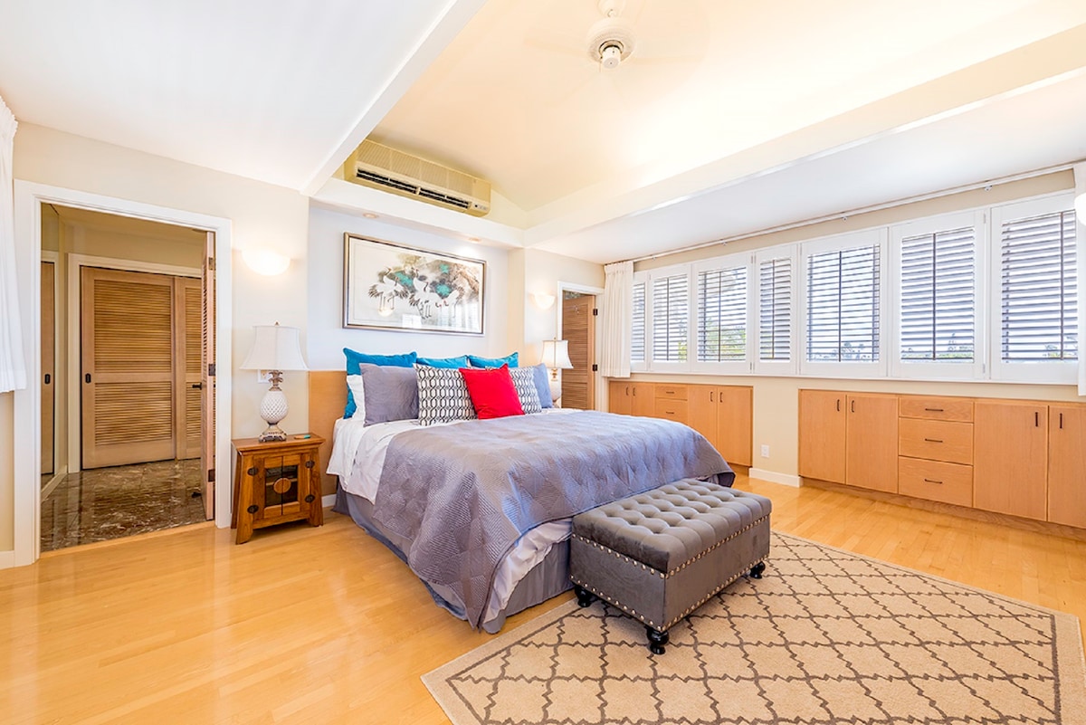 Habitación de invitados 5 Dormitorio principal con cama tamaño king y baño independiente con lavabo doble, bañera de hidromasaje y ducha separada.