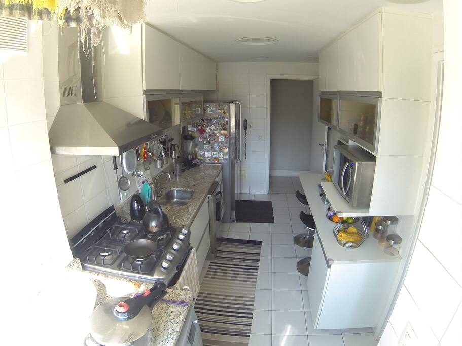 Cozinha e área de serviço com lavadora de roupas e louças, microondas, geladeira e freezer