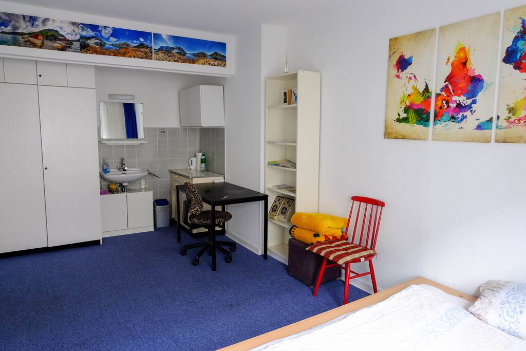 In dem großen, hellen Zimmer findest du alles, was du brauchst: Eine Kochnische, ein Waschbecken mit Spiegel, einen Ess-/Arbeitsplatz, Schränke und sogar Boxen