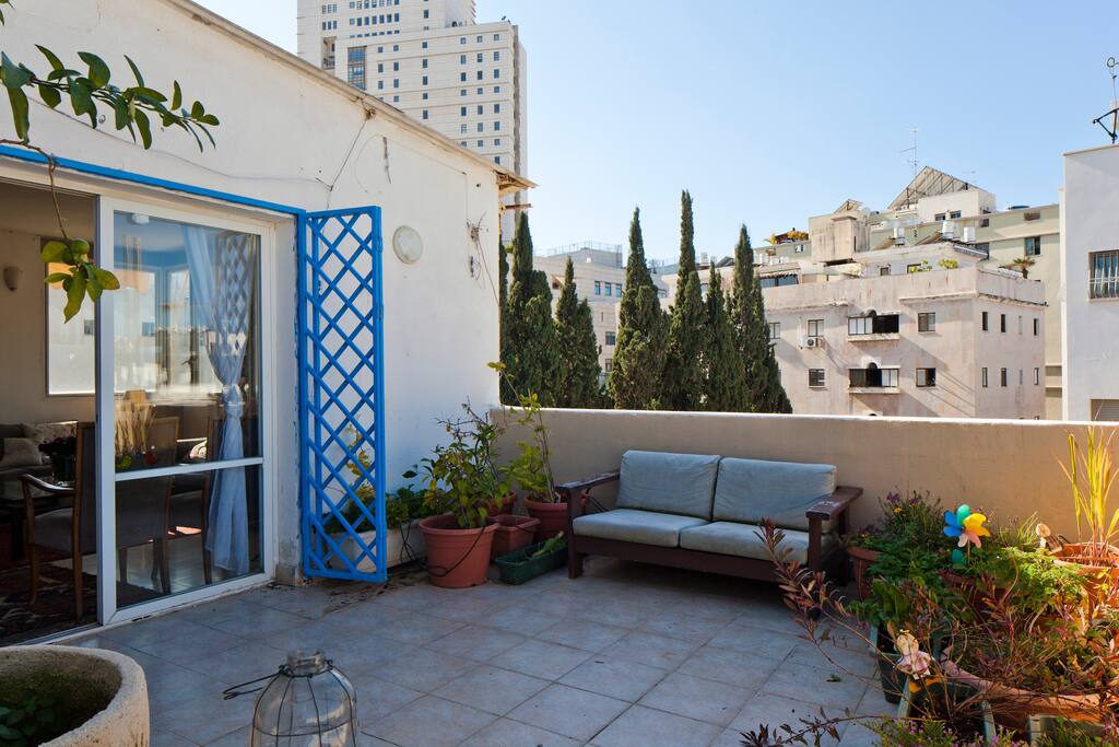 The balcony is full with flowers and herbs