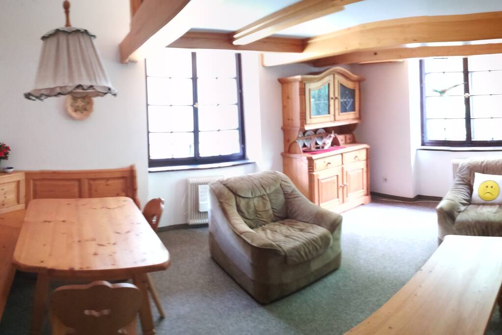 The living room has 2 big windows, a sofa, 2 armchairs, and the table. A cooling fan is available