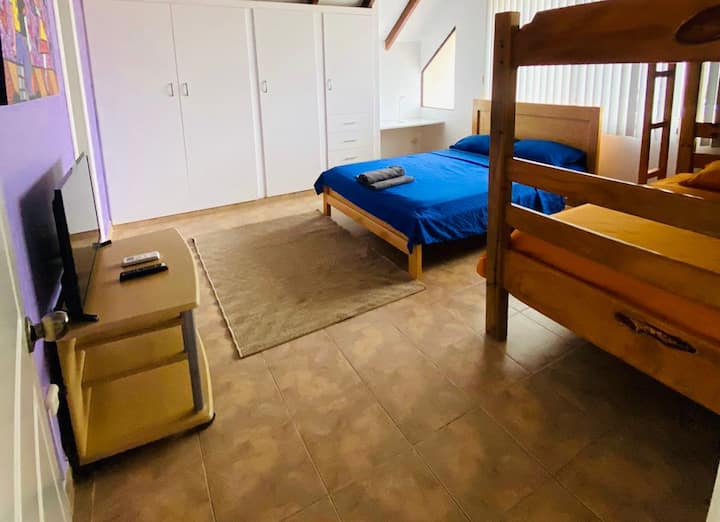 ห้องนอน 3 พร้อมเตียง 2 เตียงและเตียงสองชั้นพร้อมทีวีตู้เสื้อผ้าและโต๊ะทำงาน 