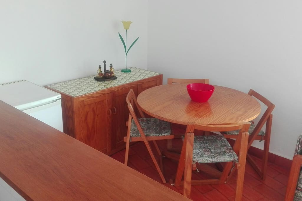 Sala com mesa de apoio/armário e mesa para refeições.