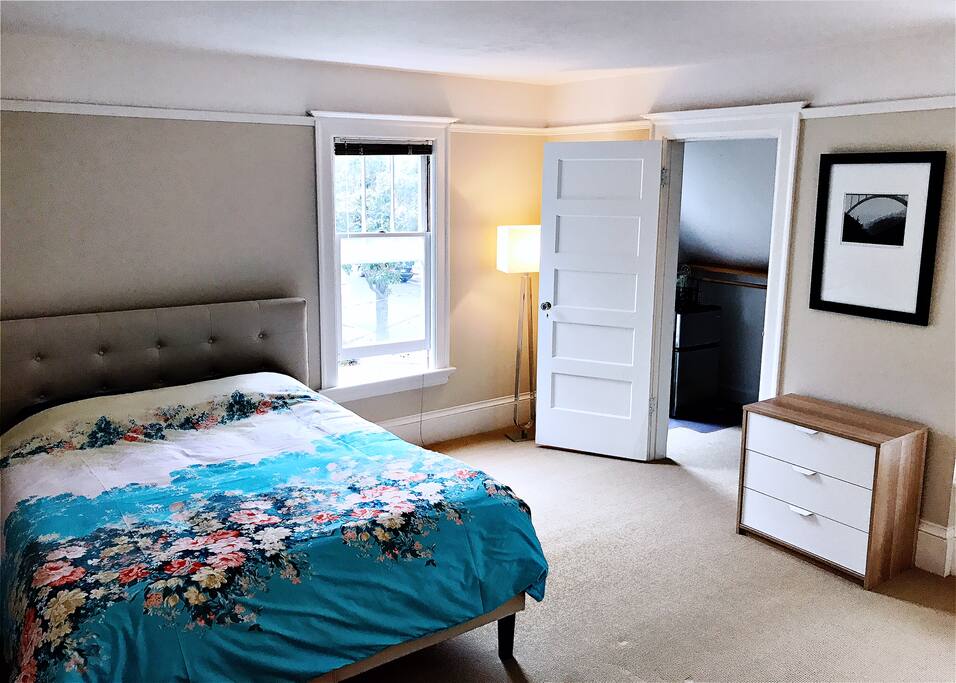 Queen bed and walk-in closet with refrigerator