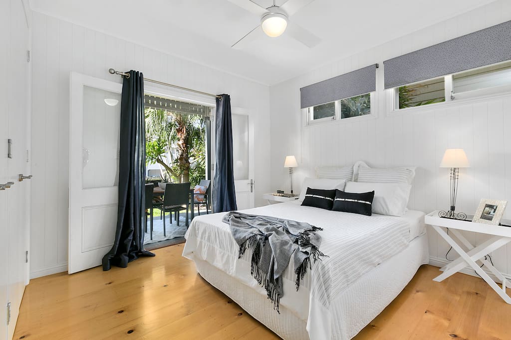 Main bed with water views leading to verandah