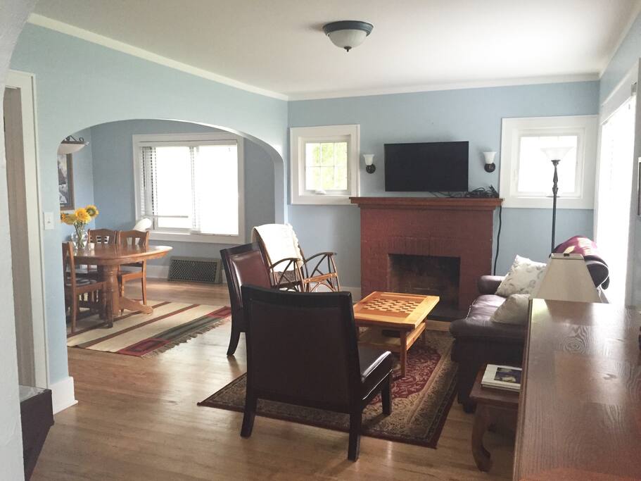 Sunny living room has a leather sofa, 2 side chairs and a rocking chair. The reclaimed wood coffee table has a built-in checker board.