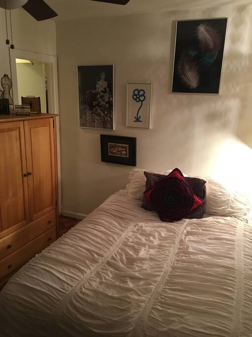 Ceiling fan in room. Private bathroom inside bedroom.