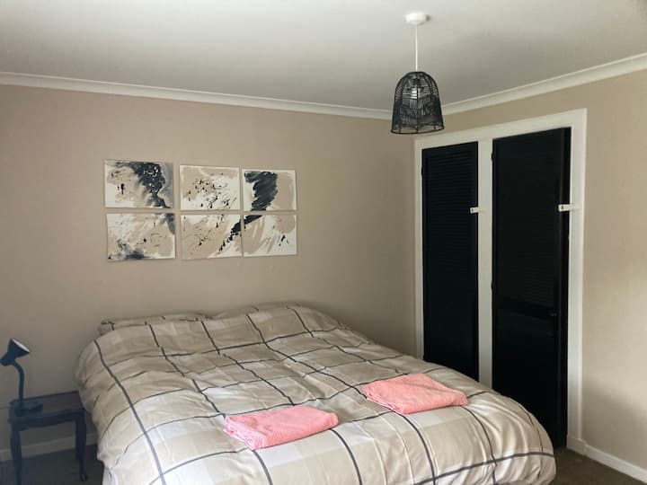 Cama tamaño king con armario empotrado y juego de cajones.